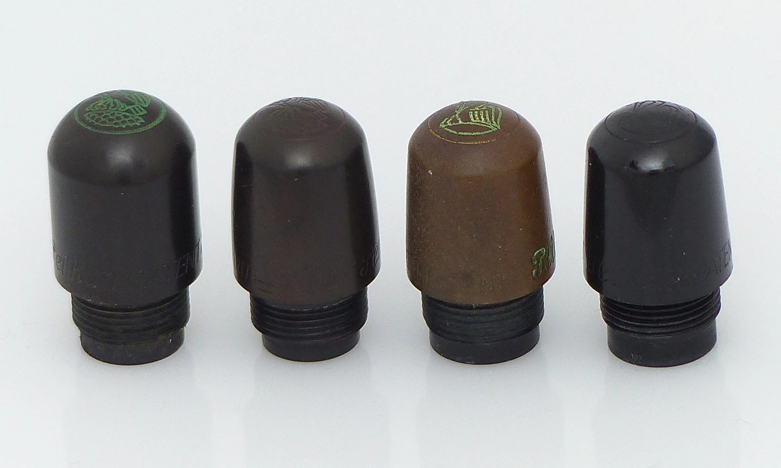 Zylindrischer Kappenkopf mit altem Logo, konisch mit altem Logo, mit neuem Logo und Spritzguss mit neuem Logo.